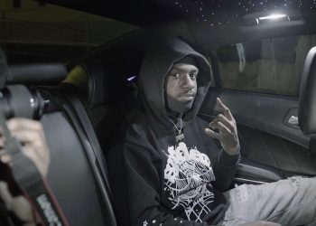 Treezy sits in the backseat of a car wearing a black hoodie, flashing a hand sign under star-lit ceiling lights—captured during a late-night creative session in Bridgeport, CT.
