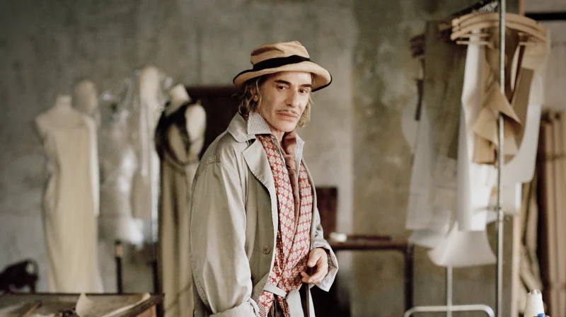 John Galliano standing inside a fashion atelier in 2026