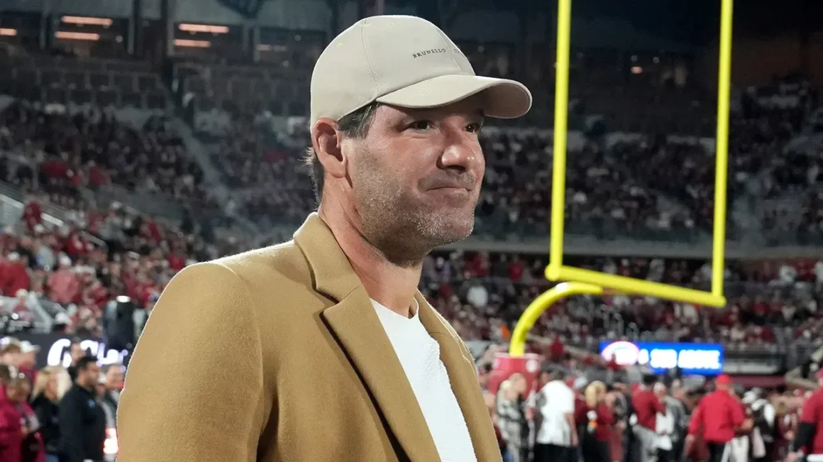 Tony Romo standing on the sideline at a football game