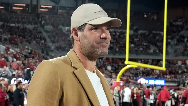 Tony Romo standing on the sideline at a football game