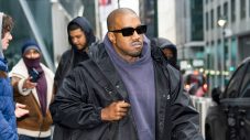 Kanye West walking in New York City wearing sunglasses and a black jacket