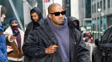 Kanye West walking in New York City wearing sunglasses and a black jacket