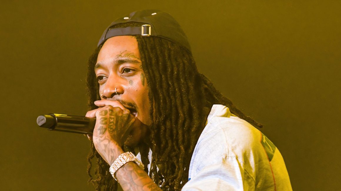 Wiz Khalifa performing onstage, the rapper who reacted to Drake and Pinkchyu’s viral barking moment.