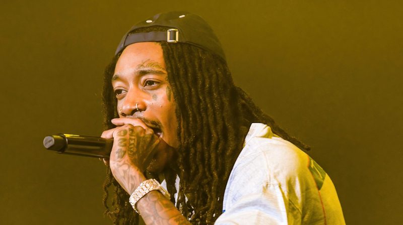 Wiz Khalifa performing onstage, the rapper who reacted to Drake and Pinkchyu’s viral barking moment.