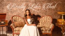 Kalabrya seated on a vintage sofa in the cover artwork for Really Like That
