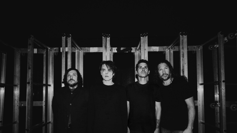 The four members of My Chemical Romance standing together in a black-and-white portrait